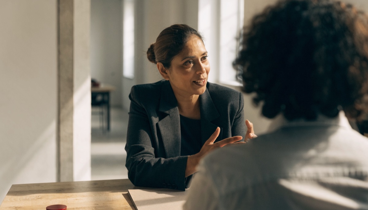 A regulated immigration consultant reviewing a client situation across a desk