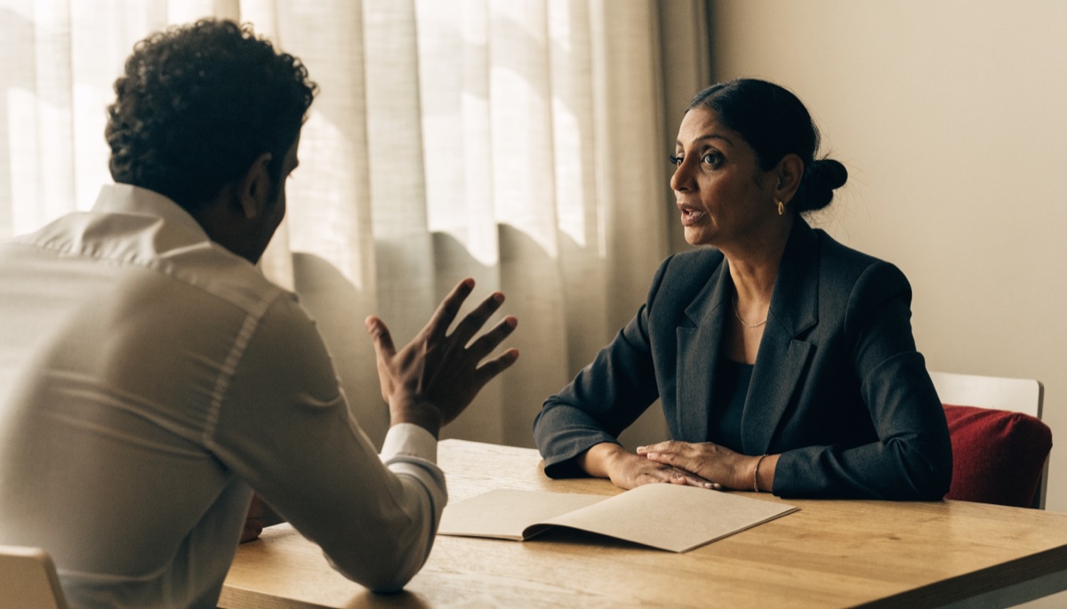 A regulated immigration consultant reviewing a client situation across a desk