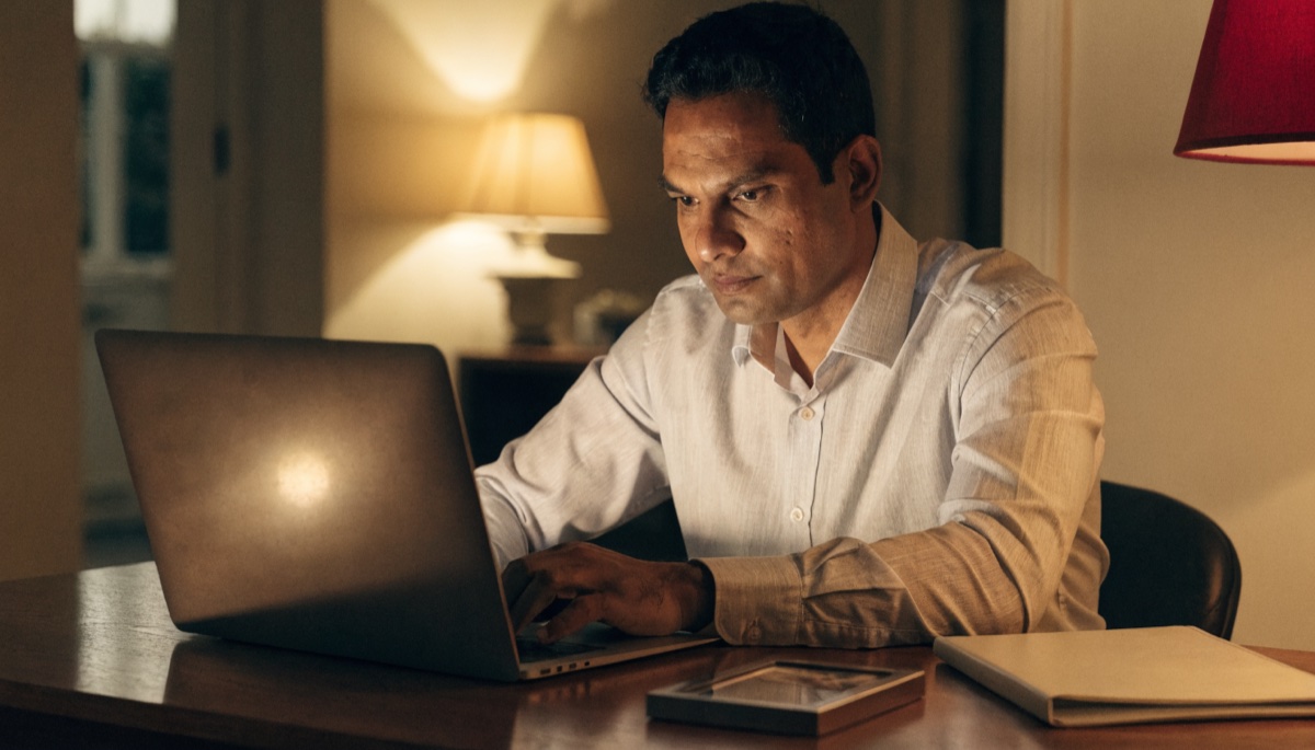 A sponsor completing forms at a desk at home