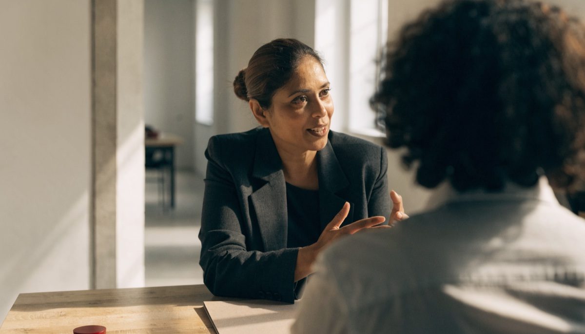 Consultant and client reviewing documents across a desk