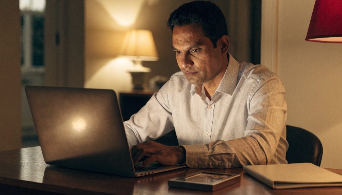 A sponsor completing paperwork at a home desk